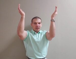 Here, you can stand straight up against a wall, hold your arms out in front of you, making a 90 degree angle by bending your forearms upwards, and then trying to push your arms up as far as they can go, stretching the lat dorsi muscles.