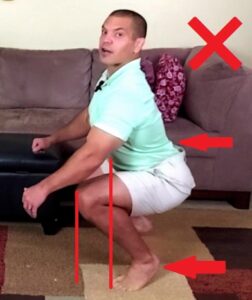 improper squat with knees in front of toes, back arched, and heels off of floor