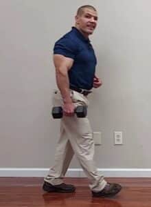 Walking single arm dumbbell carry standing core stability exercise